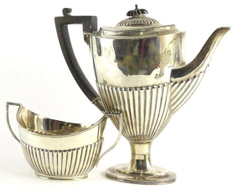 A George V silver urn shaped coffee pot, with part fluted decoration, ebonised knop and handle, on a domed foot, and a matching two handled sugar bowl, London 1911, 19½oz gross.