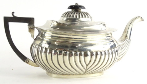 An Edwardian silver teapot, with part fluted decoration, ebonised knop and handle, Birmingham 1905, 11¾ oz gross.