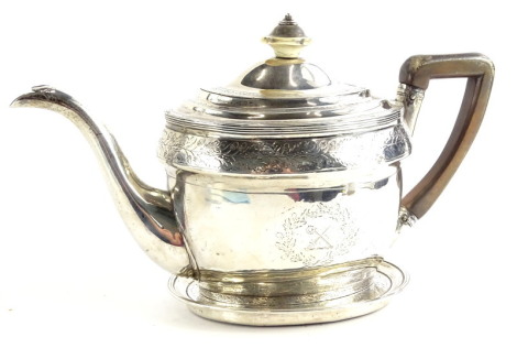 A George III Scottish silver teapot and stand, of oval form with horn knop and ebonised handle, bright cut engraving of acorns and oak leaves, the cartouche surrounding a cross swords and crook crest, the stand initialled to centre, with a weighted mahoga