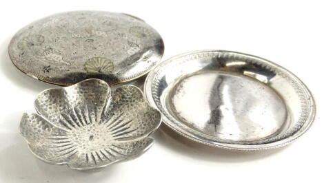 Three continental silver coloured metal items, to include a pansy shaped bowl with hammered decoration, a plated pin tray, and a compact decorated in eastern style with lions catching antelope, peacocks, etc., indistinctly stamped 925.