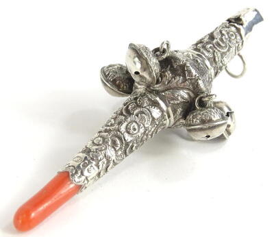 A 19thC silver rattle, with embossed decoration of scrolls, flowers, etc., and with coral teether, Birmingham 1823.