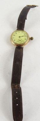 An early 20thC wristwatch, with small circular dial and white enamel watch head, with seconds dial, in yellow metal casing, unmarked, possibly 9ct gold, on a brown leather strap. - 2