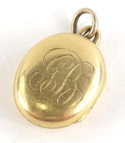 A circular locket, bearing the initials GB, yellow metal, unmarked, 2cm high, 5.2g all in.