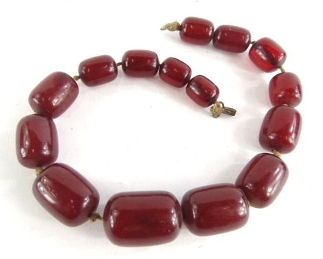 A cherry amber beaded necklace, with oblong beads, the largest 2.5cm wide, the smallest 2cm wide, 76.2g all in.