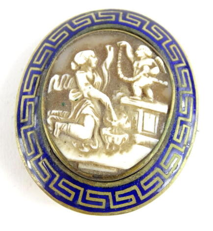 An early 20thC oval brooch, with shell cameo, central insert of a lady and child, with a blue enamel Greek style key frame, on a polished silver gilt back, unmarked, 5cm x 6cm, 23g all in.