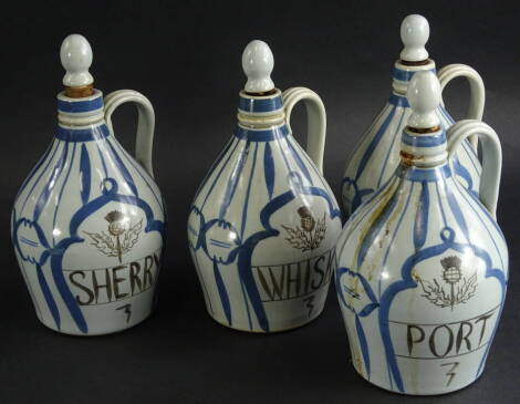 A set of four Buchan stoneware decanters whisky, 26cm high, sherry, port and gin, each in blue and white, decorated with thistles in brown, printed marks beneath (4).