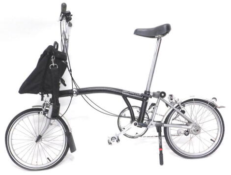 A Brompton black folding bicycle, with Marathon tyres, single bag etc.