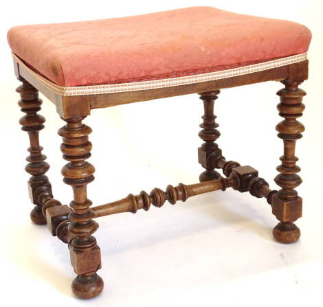 A 19thC walnut stool, with a padded top on turned supports with H stretcher.