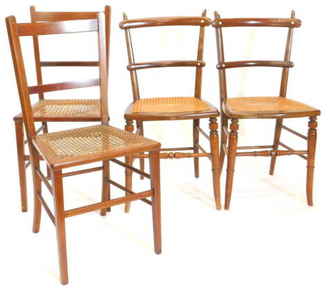 Two pairs of bedroom chairs, a pair of Edwardian satinwood and boxwood strung chairs, each with a can seat, and a pair of Victorian ladderback chairs, each set with ivorine roundels, and a cane seat, on turned tapering legs.