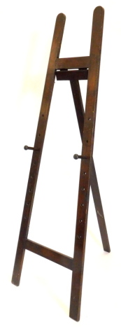 A stained pine easel, with two turned wooden rests, 197cm high.