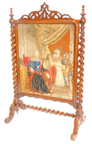 A Victorian rosewood firescreen, with a pierced crest above a wool work panel depicting King Charles etc., flanked by spirally turned supports, on splayed legs, 132cm high, 83cm wide, 52cm deep.