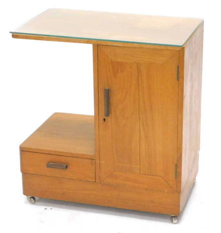 An Art Deco teak side cabinet, the rectangular top above a cupboard, flanked by a recess and a drawer, on a plinth base with castors, 66cm high, 39cm wide, 62cm deep.