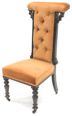 A 19thC prie dieu chair, with 'T' shaped overstuffed back and seat in (later) peach material, on turned front tapering legs, terminating in castors, 97cm high.