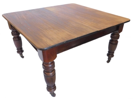 A Victorian walnut and pine extending dining table, the rectangular top with rounded corners on turned fluted legs with ceramic castors and two loose leaves, the top (AF), 74cm high, the top 122cm x 192cm.