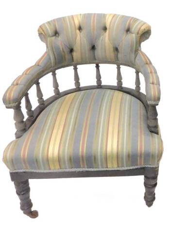 An Edwardian button back armchair, upholstered in striped fabric on square tapering legs with brass castors.