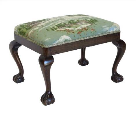 A mahogany stool in George III style, with padded seat on cabriole legs with ball and claw feet.