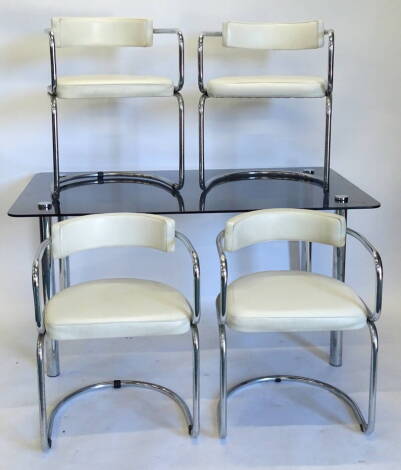 A 1970s/1980s smoked glass and chrome rectangular dining table, and four matching chairs, each with white leather upholstery, the table 71cm high, the top, 81cm x 142cm. The upholstery in this lot does not comply with the 1988 (Fire & Fire Furnishing) Reg