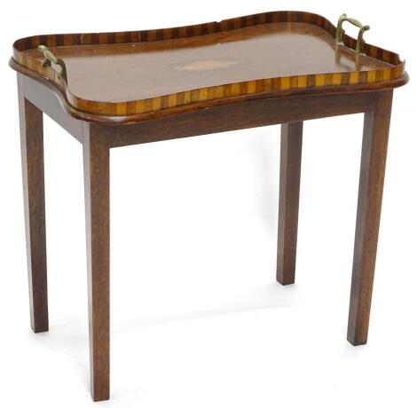 A mahogany tray table, the top with a raised checkered gallery, two brass handles and a central oval inlaid shell, on later square tapering legs, 52cm wide.