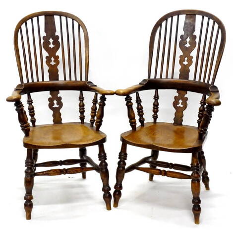 A pair of 19thC and elm Windsor chairs, each with a high back and a Christmas tree type pierced splat, on turned supports with solid seat, on turned legs with H stretcher.