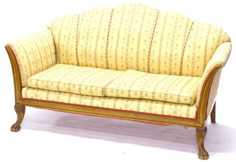 A continental mahogany sofa, upholstered in gold pattern fabric, with a shell shaped back, show frame to the arm supports and frieze, on cabriole legs with paw feet, 157cm wide