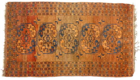 A Turkomen type Afghan rug, with five medallions, on an orange ground with multiple borders, 113cm x 189cm.