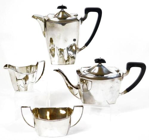 A George V silver four piece tea service, of plain form, comprising teapot, water jug 20cm high, milk jug and two handled sugar bowl Birmingham 1934, 61oz all in. (4)