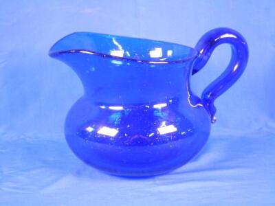 A 19thC Bristol blue glass jug with a scroll handle