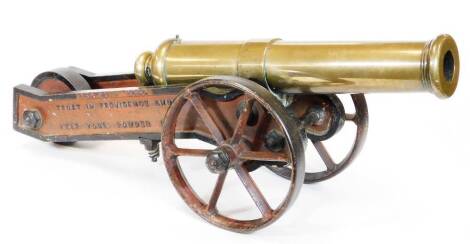 A Mid 19thC brass signal cannon, with cylindrical barrel on a shaped truckle base, inscribed PEACE 1856 TRUST IN PROVIDENCE AND KEEP YOUR POWDER DRY with two large spoked front wheels and central back wheel, with X design, 37cm high, 75cm wide, 39cm deep.