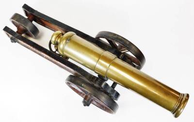 A Mid 19thC brass signal cannon, with cylindrical barrel on a shaped truckle base, inscribed PEACE 1856 TRUST IN PROVIDENCE AND KEEP YOUR POWDER DRY with two large spoked front wheels and central back wheel, with X design, 37cm high, 75cm wide, 39cm deep. - 4