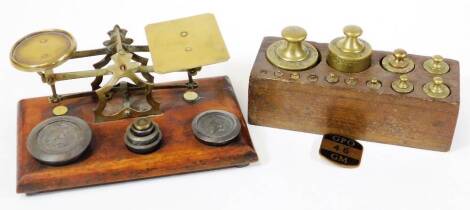 A set of Victorian brass and mahogany postal scales with weights, and a further oak block of weights. (2)