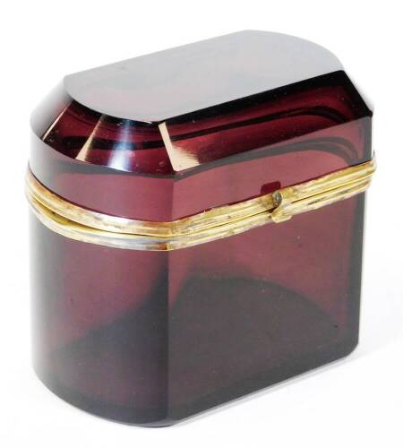 An early 20thC amethyst coloured glass casket, of oblong form, with hinged lid, metal mounts and plain interior, 14cm high, 15cm wide, 9cm deep.