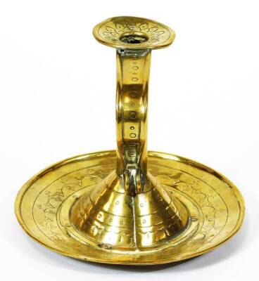 An 18thC brass candlestick, with cylindrical stem, shaped handle and circular plate base, decorated with a repeat leaf and berries pattern, 18cm high. - 2