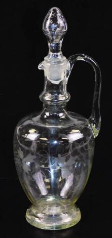 A 19thC glass decanter, with shaped stopper, moulded lip and plain handle, the bulbous body etched with leaves and berries, on a circular foot, with a rough pontil, 31cm high.