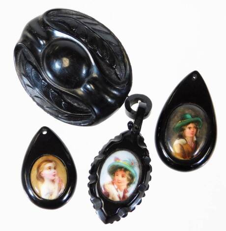 A small selection of jet jewellery, comprising on oval jet leaf brooch, two portrait set pendants with small necklace hole, and another portrait pendant with loop. (4)