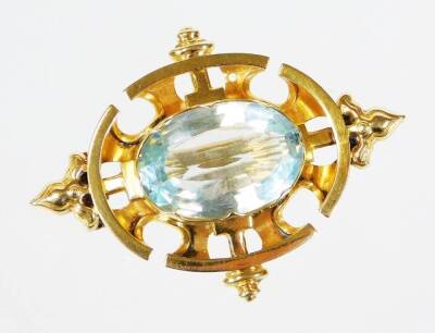 An early/mid 20thC aquamarine set brooch, with urn and crest design borders, in a yellow metal frame, unmarked, believed to 18ct but unmarked and untested, 4.5cm wide, 7.4g all in.