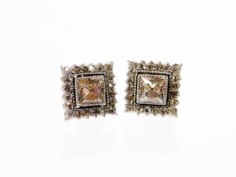 A pair of 9ct gold white gold earrings, each of square design set with central diamond and surrounded by tiny diamonds, with butterfly backs, 9mm wide, 2.3g all in.