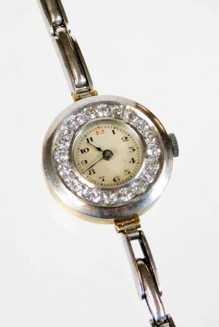 A 1920's/30's diamond set cocktail watch, on a later bracelet, the watch head with small cream coloured dial, surrounded by nineteen round brilliant cut diamonds, in white metal casing, with a yellow metal back, unmarked, on a later expanding bracelet, th