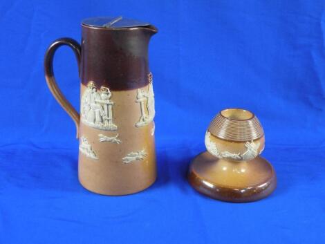 A Royal Doulton stoneware hot water jug decorated in relief with rural scenes