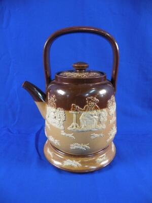 A Doulton Lambeth stoneware tea kettle and lid decorated in relief with rural scenes etc