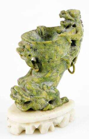 A Chinese mottled green hardstone rhyton cup with carved chilin, fixed white marble finish base, 19cm high.