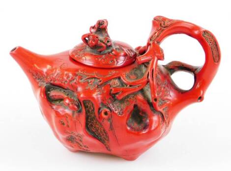 A Chinese teapot, raised with flowers and insects with naturalistic bark handle, plain spout and removable lid, mark beneath, 10cm high.