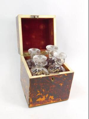 A Georgian blonde tortoiseshell and ivory strung tantalus, of square section, the hinged lid with silver carrying handle, opening to reveal four cut glass decanters and stoppers, 22.5cm H, 18.5cm W, 8.5cm D.
