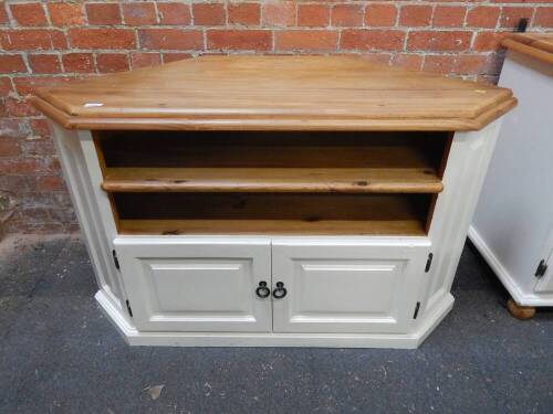 A pine and white painted corner cupboard, with two shelves above a pair of cupboard doors raised on a plinth base, 76.5cm high, 124cm wide, 56cm deep.