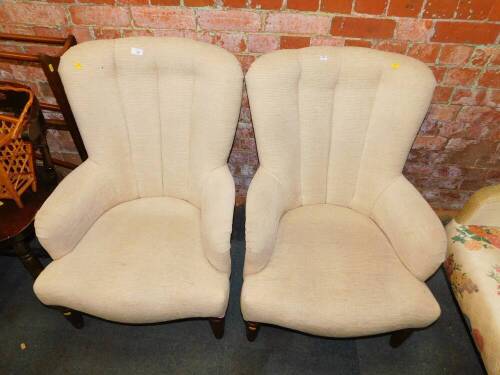 A pair of nursing chairs, upholstered in fawn coloured fabric.