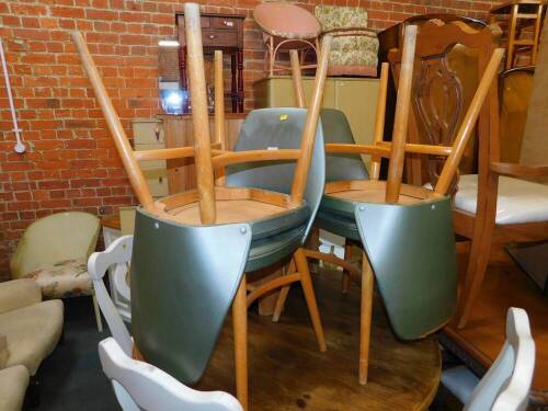 A set of four Ben beech kitchen chairs, upholstered in silver vinyl.