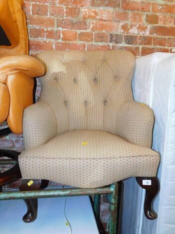 A nursing chair upholstered in button back striped fabric.