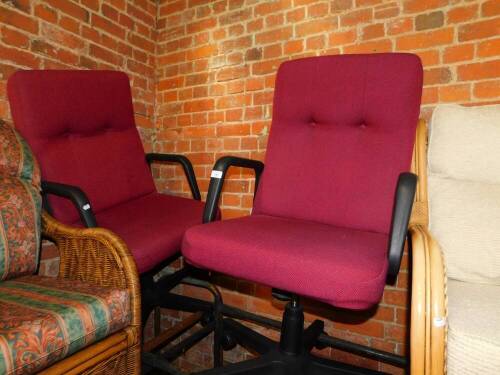 A pair of swivel office chairs upholstered in red button back fabric.