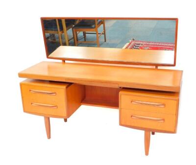 A G-Plan teak dressing table, with a rear attached rectangular swing frame mirror, above a central jewellery drawer, over four further drawers, raised on tapering legs, 119cm high, 152.5cm wide, 45.5cm deep.