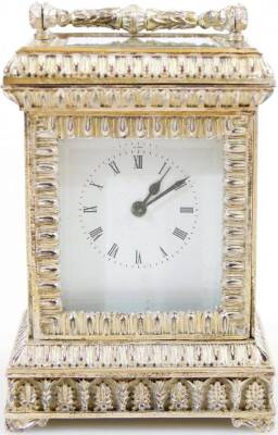 An Elizabeth II silver carriage clock, of small proportion, in elaborate five panel glass case with swing handle, on shaped feet with a lower acanthus leaf border and 3cm back plate with Roman numeric dial and keywind single train movement, marked Made In - 2