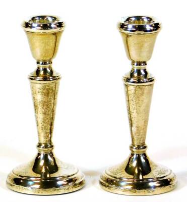 A pair of Elizabeth II silver candlesticks, with tapering cylindrical stems on domed feet, Birmingham 1970, 13cm high, 5oz. (2, weighted)